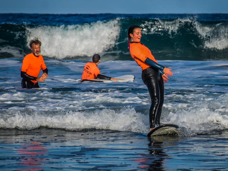One surf school student is trying to stand up